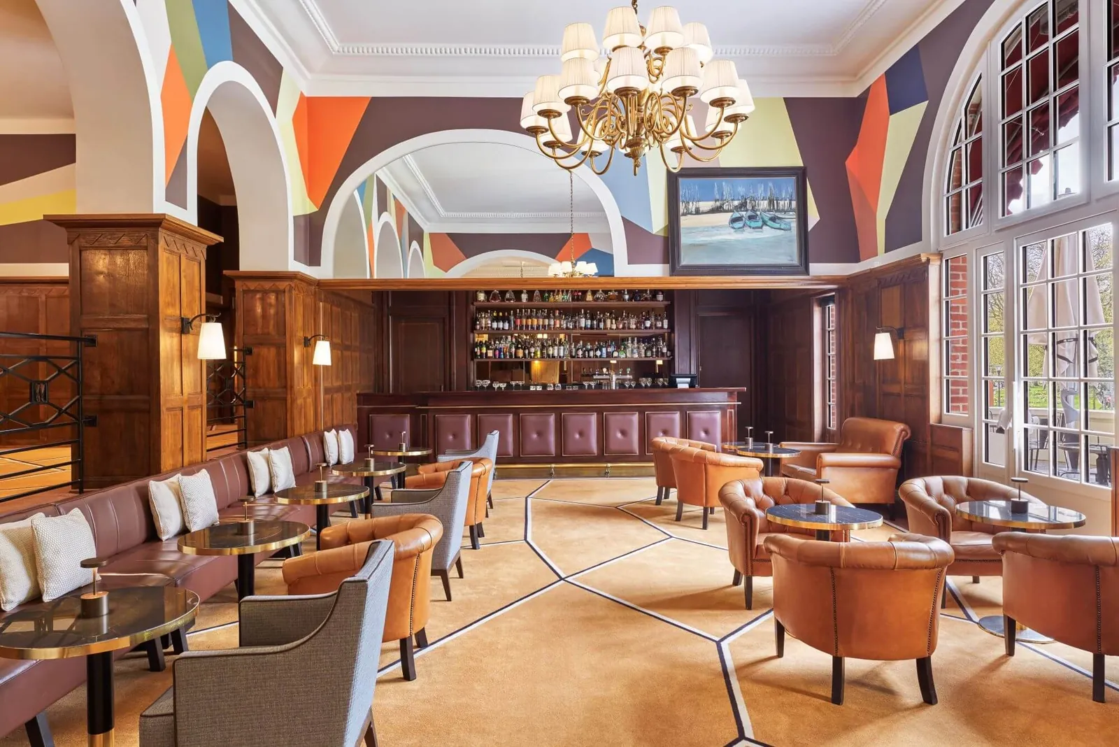 Lounge bar with leather armchairs, a painted ceiling and chandelier at Hôtel Barrière Le Westminster