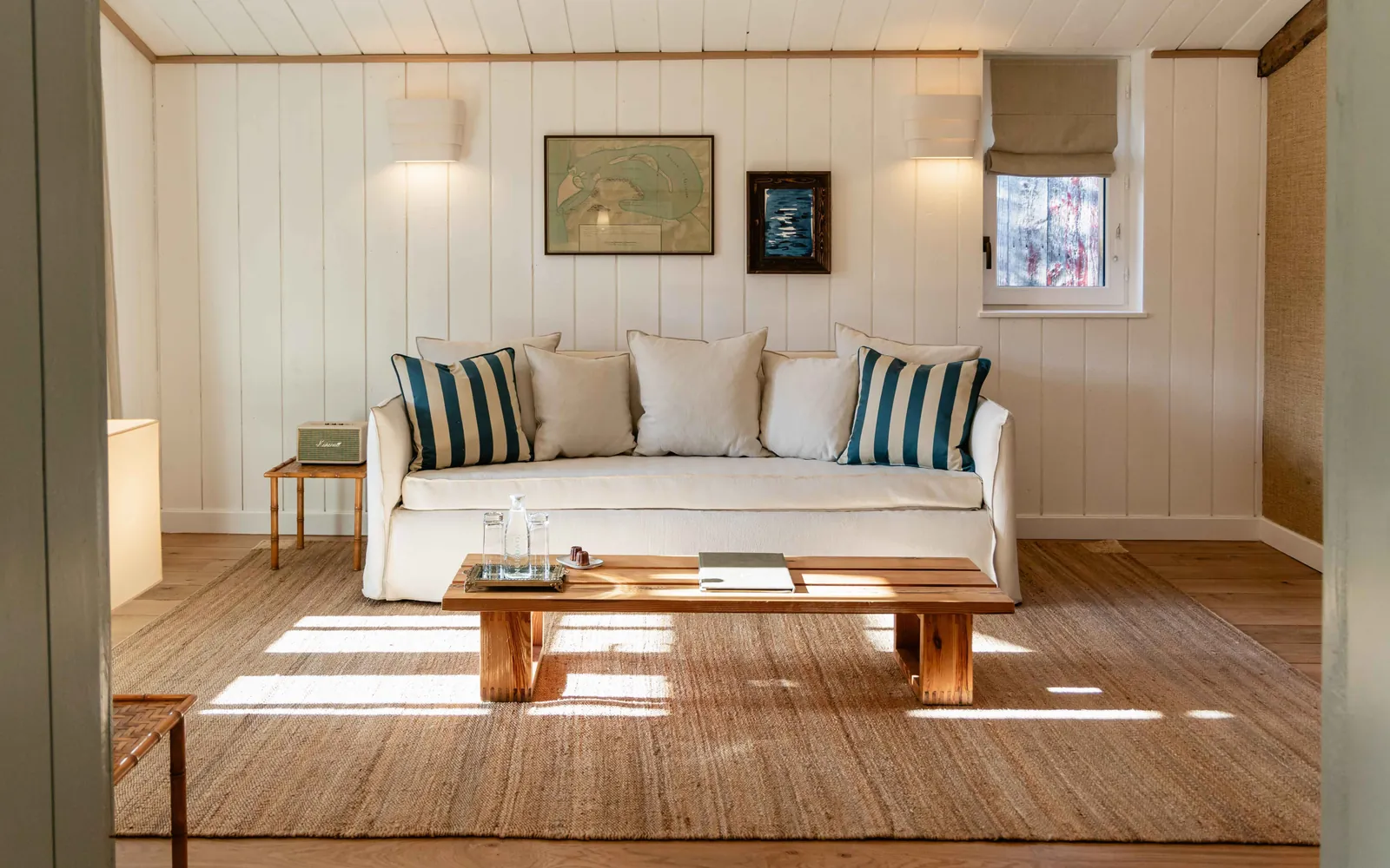 Lounge with cream sofa, striped cushions and sunlit oak floor at Les Sources de Caudalie, Bordeaux