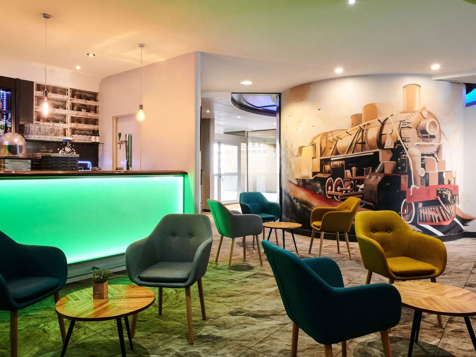 Green-lit bar and steam-train mural in the lounge at Mercure Rennes Centre Gare, Rennes
