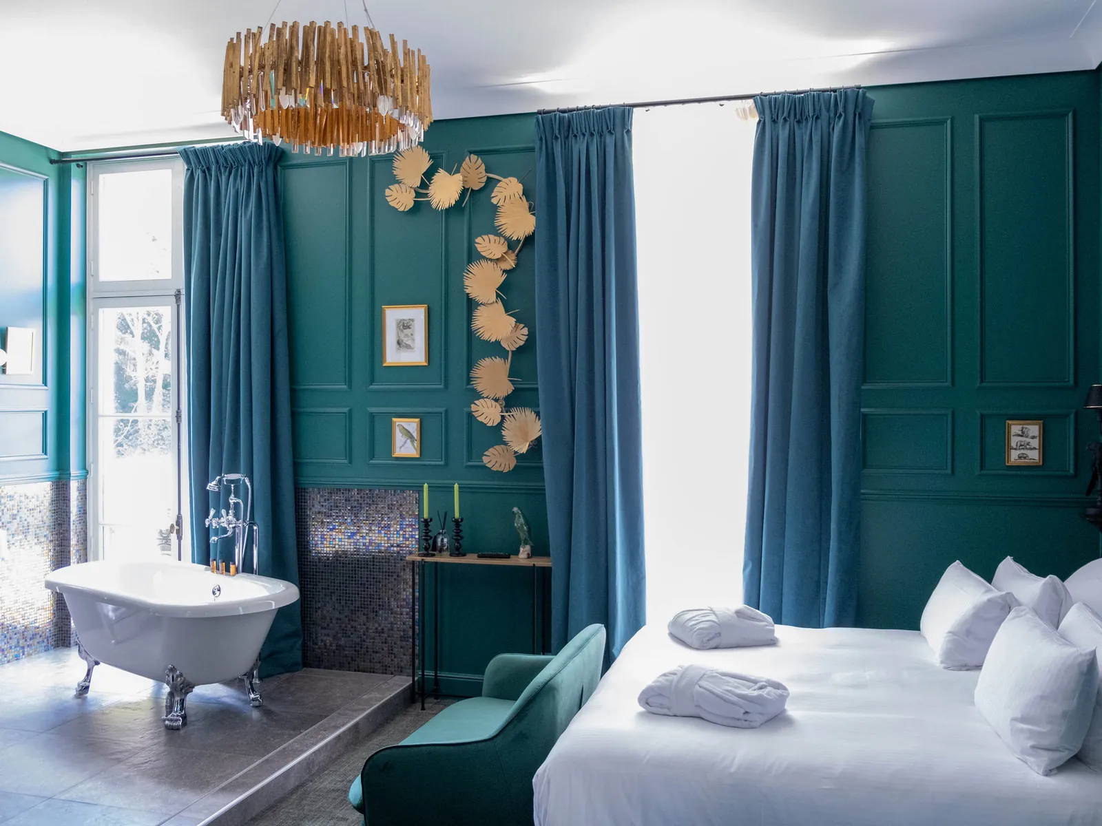 Suite du Novotel Domaine de Maffliers aux murs bleu canard, baignoire ancienne et grand lit