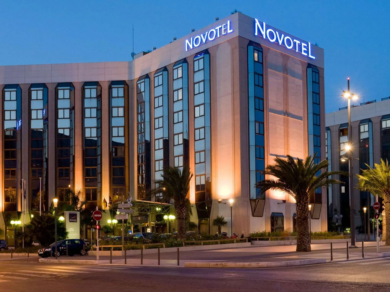 Facade of Novotel Nice Centre Vieux Nice lit up at dusk, in the city centre near the old town