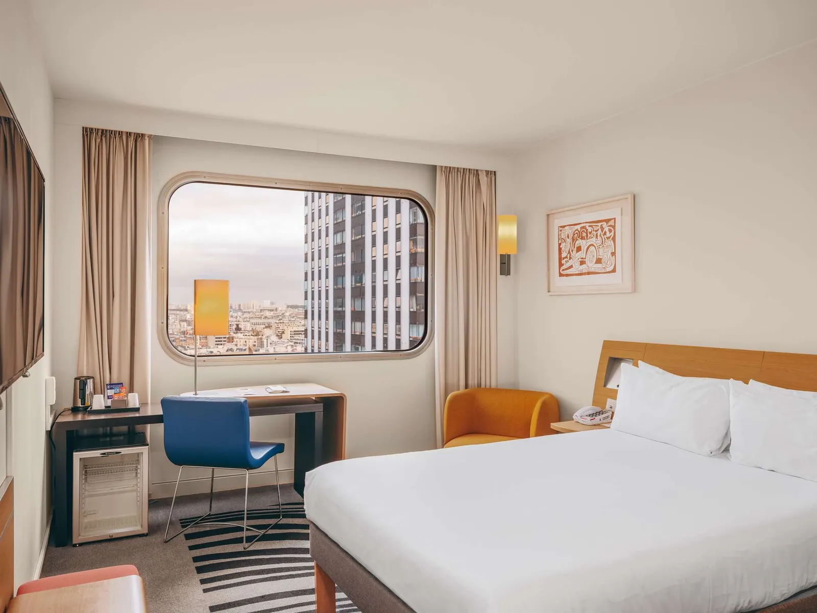 Guest room with a window view over Paris rooftops at Novotel Paris Centre Tour Eiffel