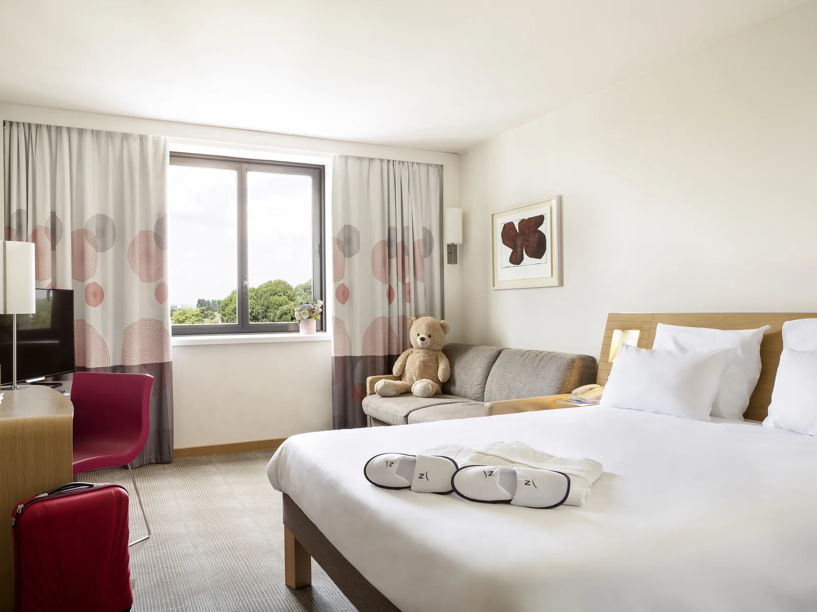 Superior room at the Novotel Paris Roissy CDG Convention with a double bed, sofa and armchair