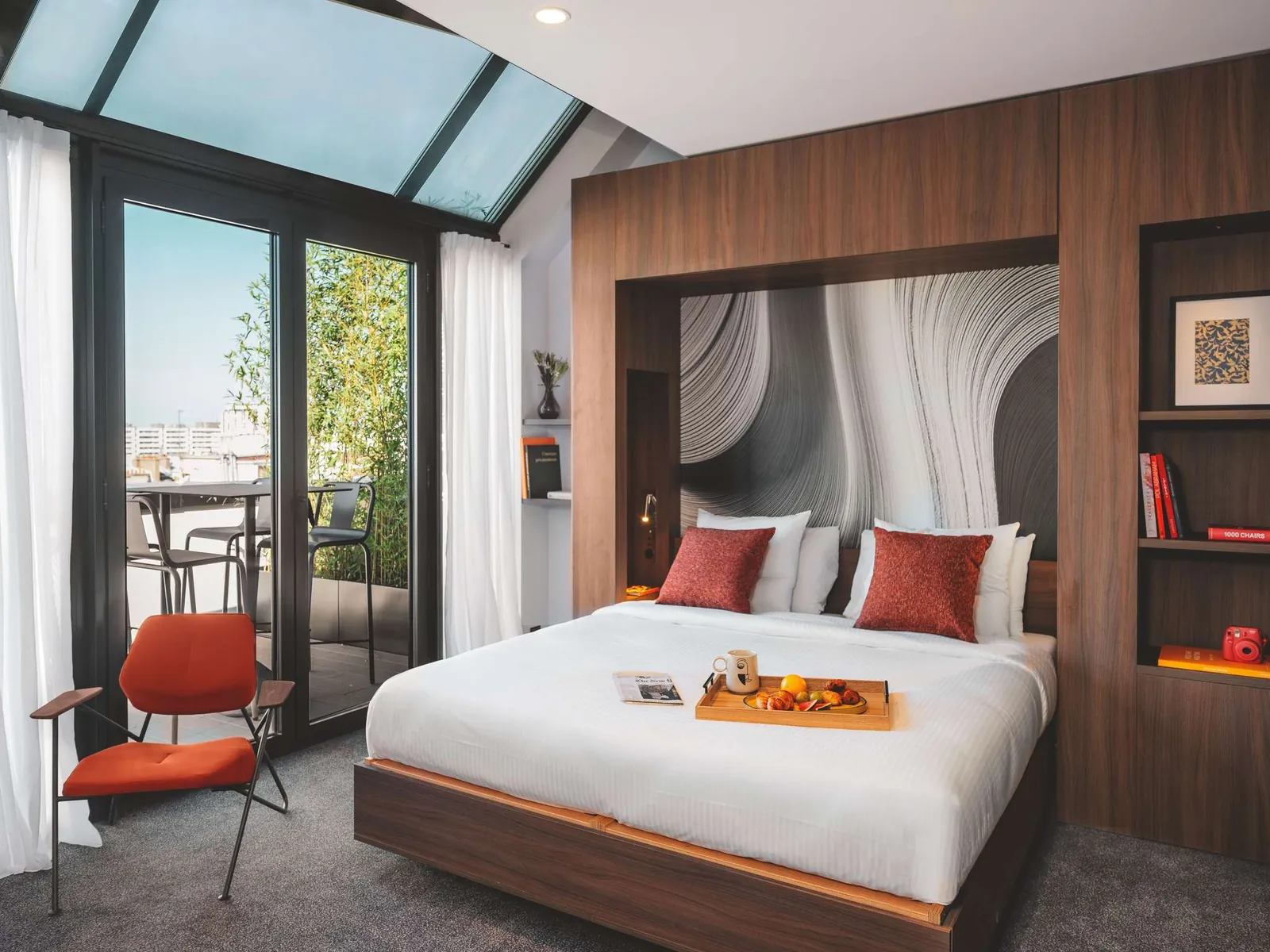 Room with a red armchair, a bed and doors onto the terrace at Novotel Paris Vaugirard Montparnasse