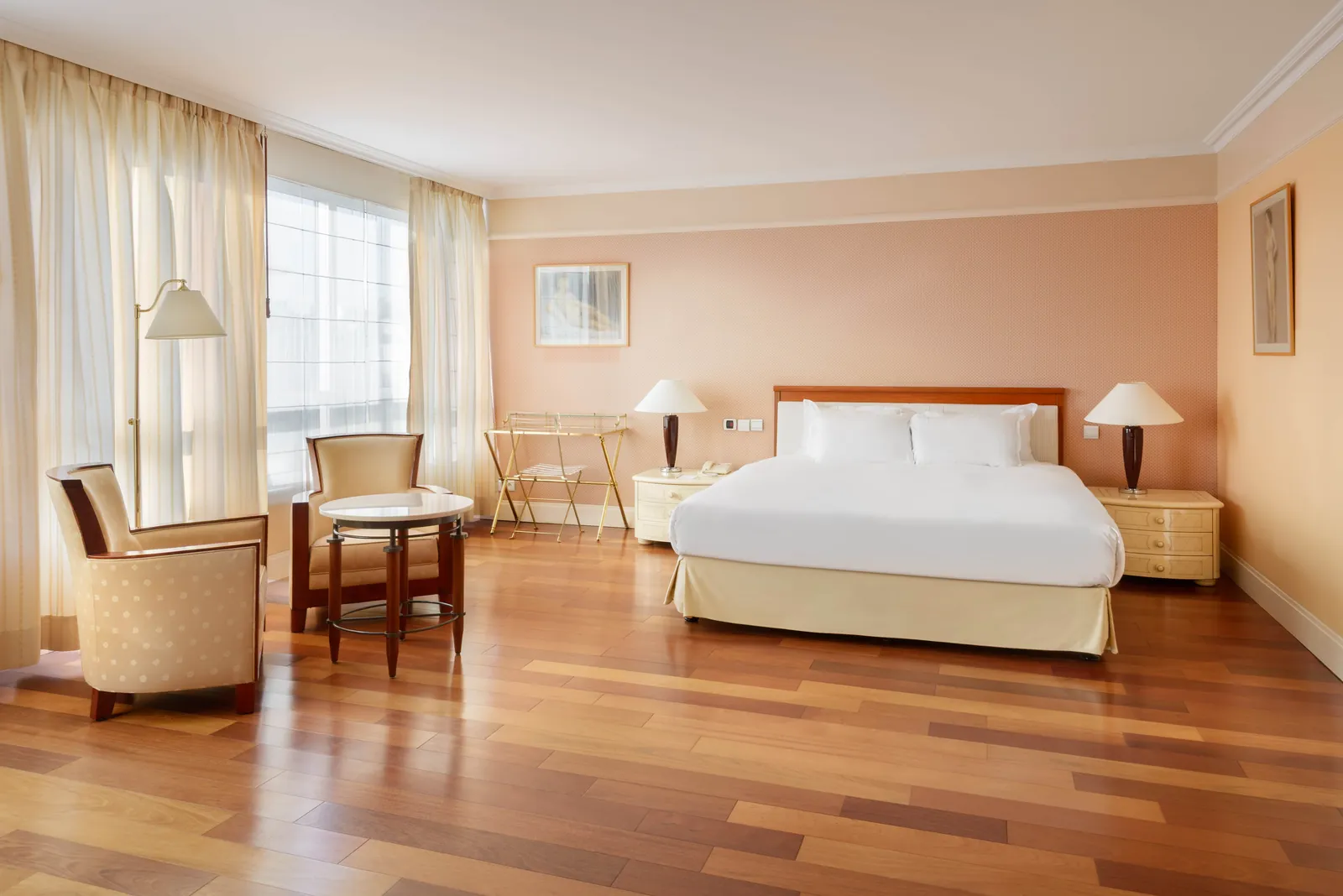 Presidential suite with a king bed, parquet floor and armchairs at Occidental Paris Levallois