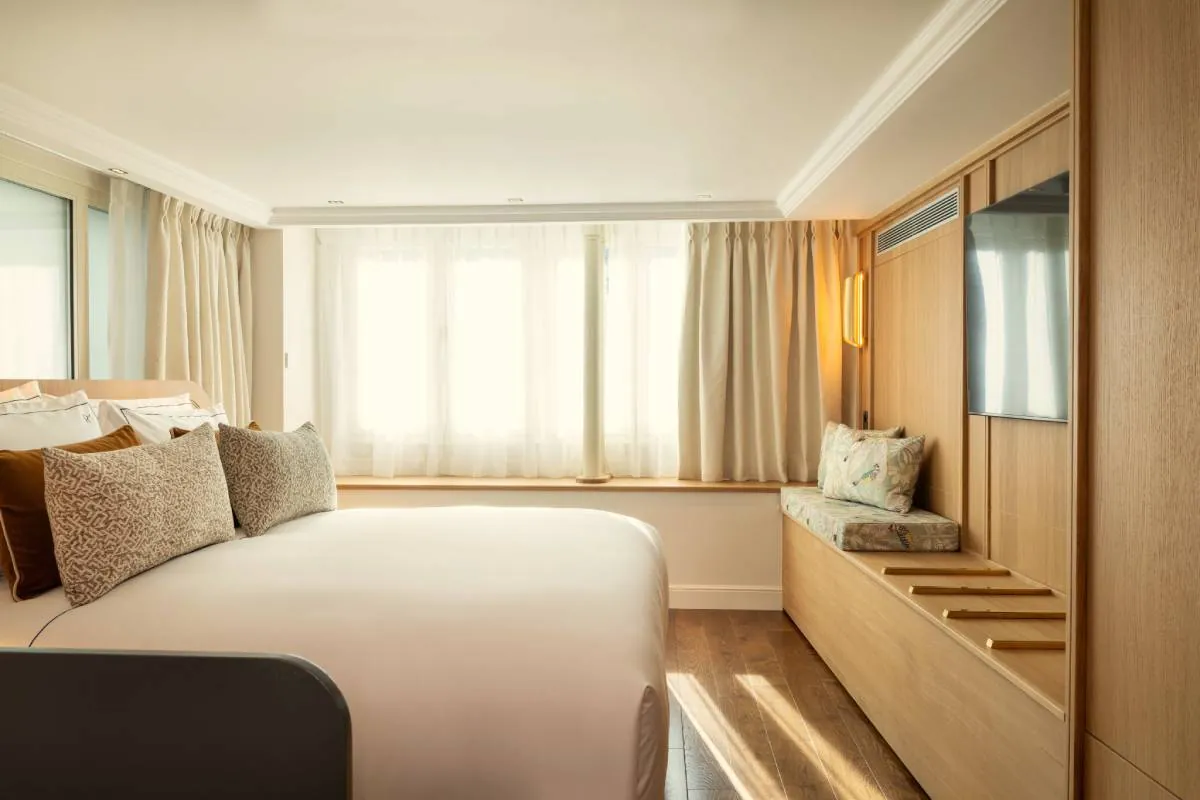 Chambre de l'Hôtel & Spa Royal Madeleine à Paris avec lit double et banquette sous la fenêtre