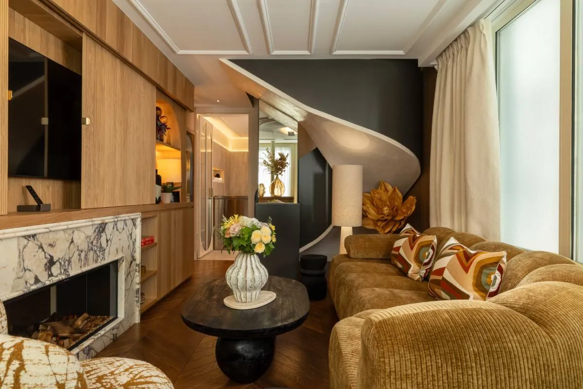 Salon d'une suite de l'Hôtel & Spa Royal Madeleine à Paris, avec cheminée en marbre et escalier