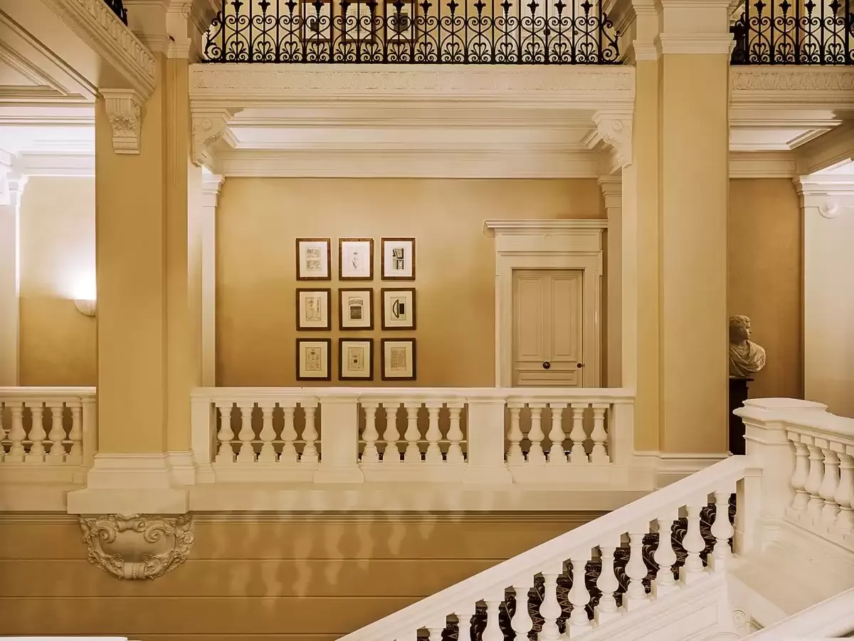 Stone staircase with a carved balustrade and framed artworks at Saint James Paris, Paris