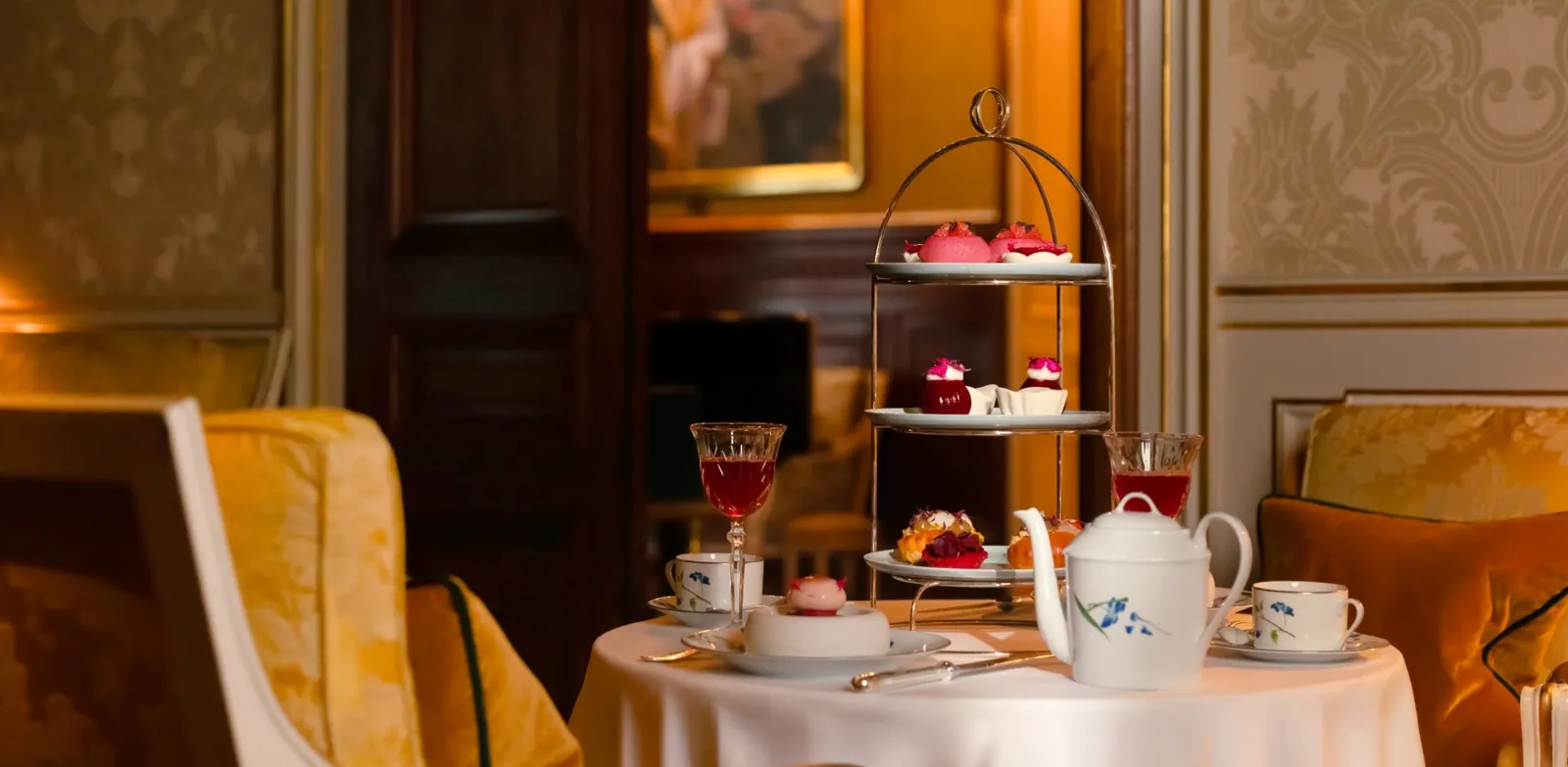 Afternoon tea served on a tiered stand with pastries and teapot in a gilded salon at Shangri-La Paris