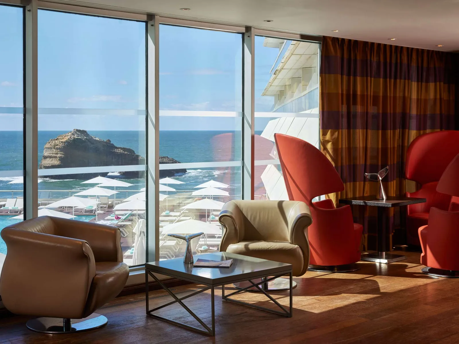 Lounge with red armchairs and a panoramic sea view at Sofitel Biarritz Le Miramar, Biarritz