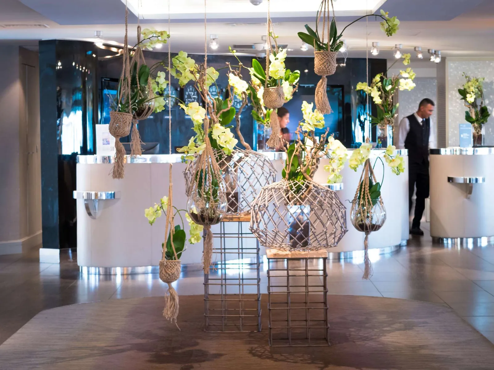 Reception desk decorated with tall floral arrangements at Sofitel Marseille Vieux-Port, Marseille