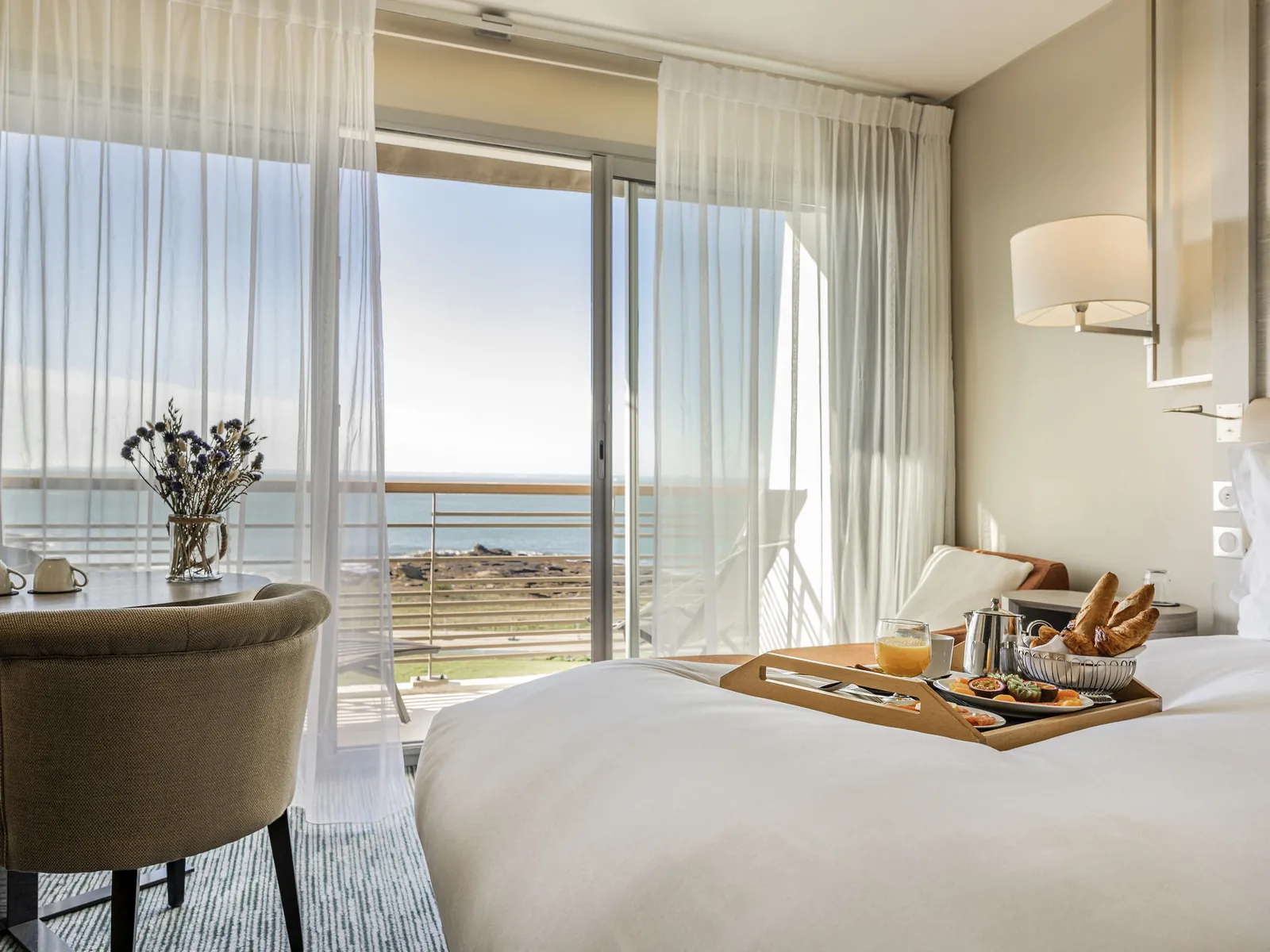 Guest room with sea view, breakfast tray and sheer curtains at Sofitel Quiberon Thalassa sea & spa