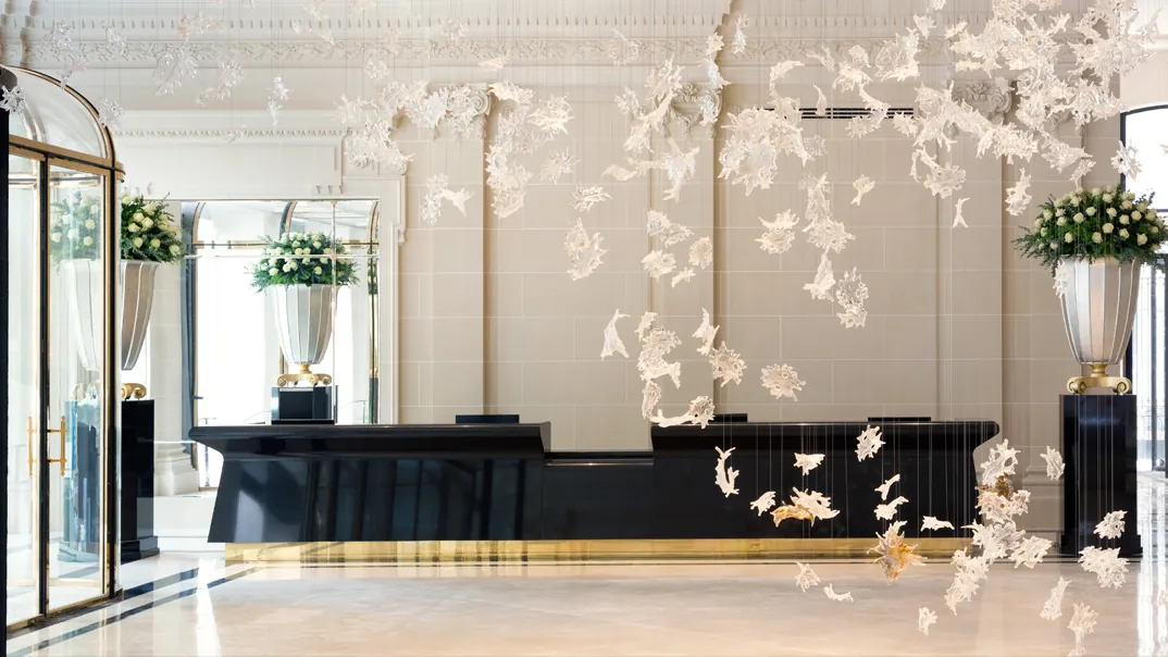 Reception desk and sculptural white floral installation in the lobby of The Peninsula Paris
