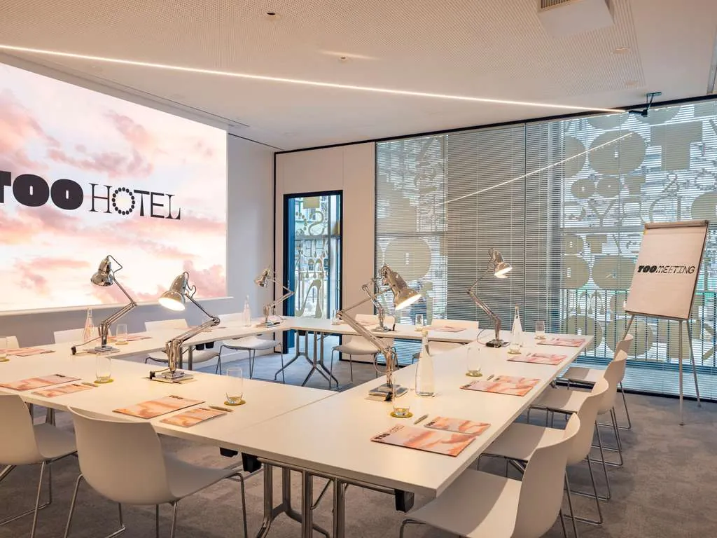 Meeting room at TOO Hotel & Spa Paris MGallery, Paris 13th, with a large screen and rows of white tables