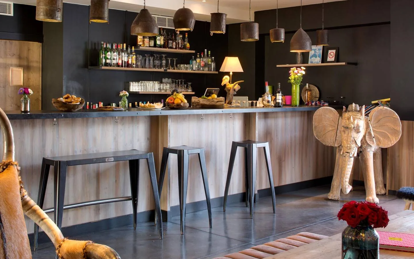 Hotel bar with pendant lamps and bar stools at Vila de la Mar, Camargue