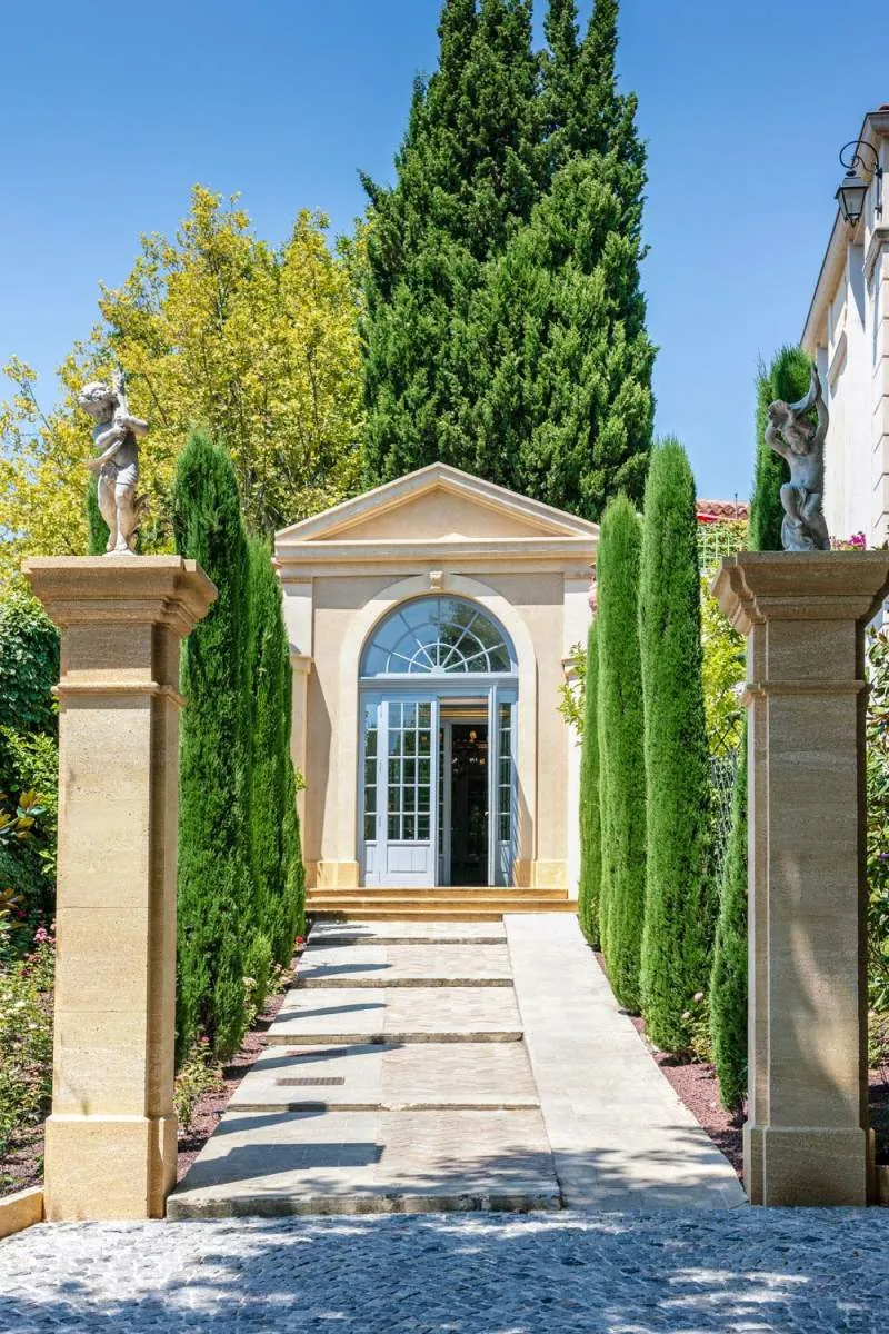 Stone-framed entrance path lined with cypress trees at Villa Gallici, Aix-en-Provence