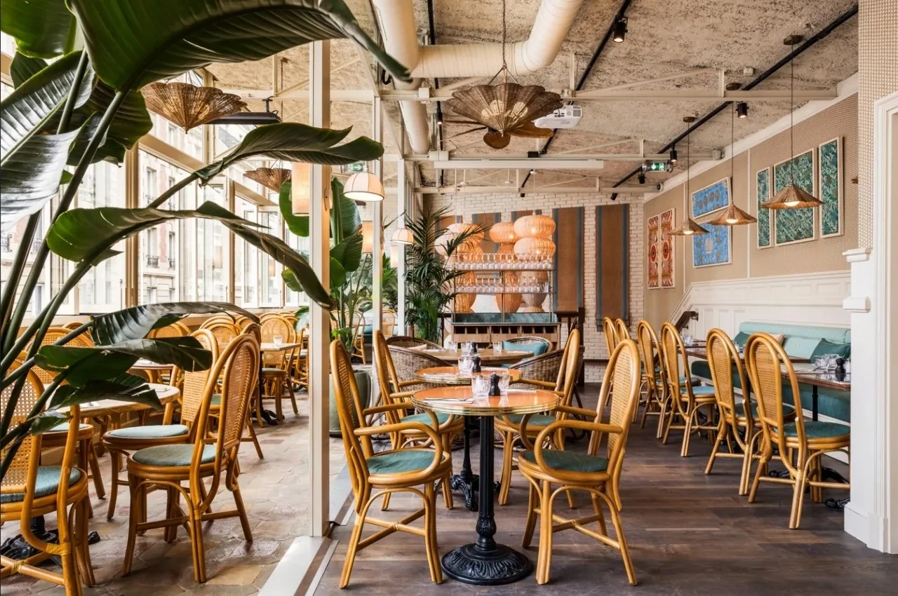 Salle de brasserie lumineuse avec plantes et chaises en rotin