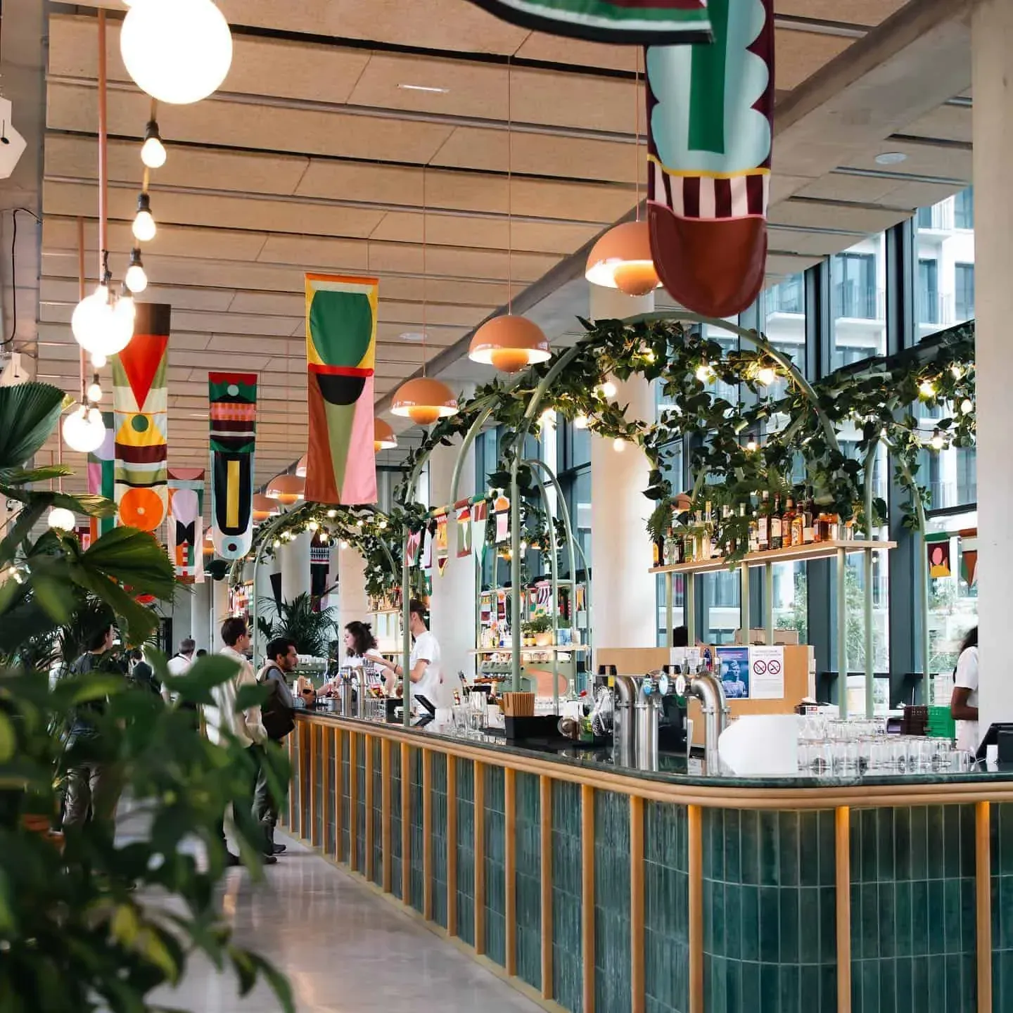 Art Deco brasserie interior with a long bar and plants
