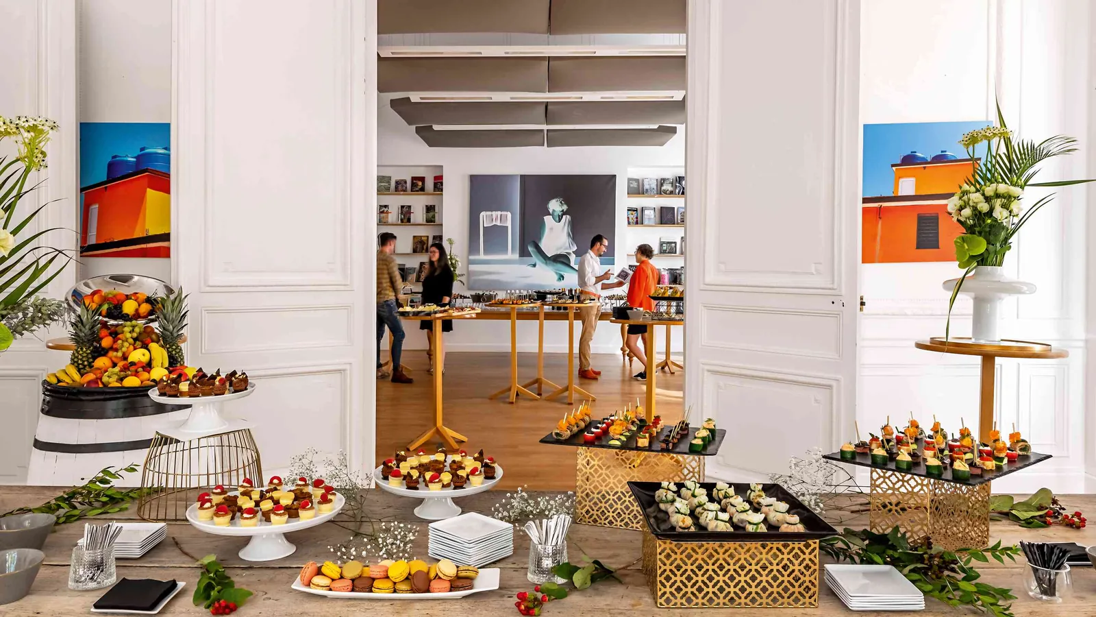 Réception à l'Atelier Lumière avec corbeilles de fruits, buffet et invités en lumière du jour