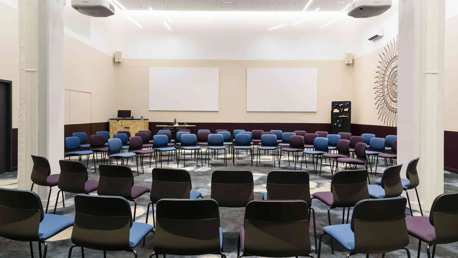 Auditorium du Belvédère Nord avec rangées de sièges bleus et gris face aux écrans