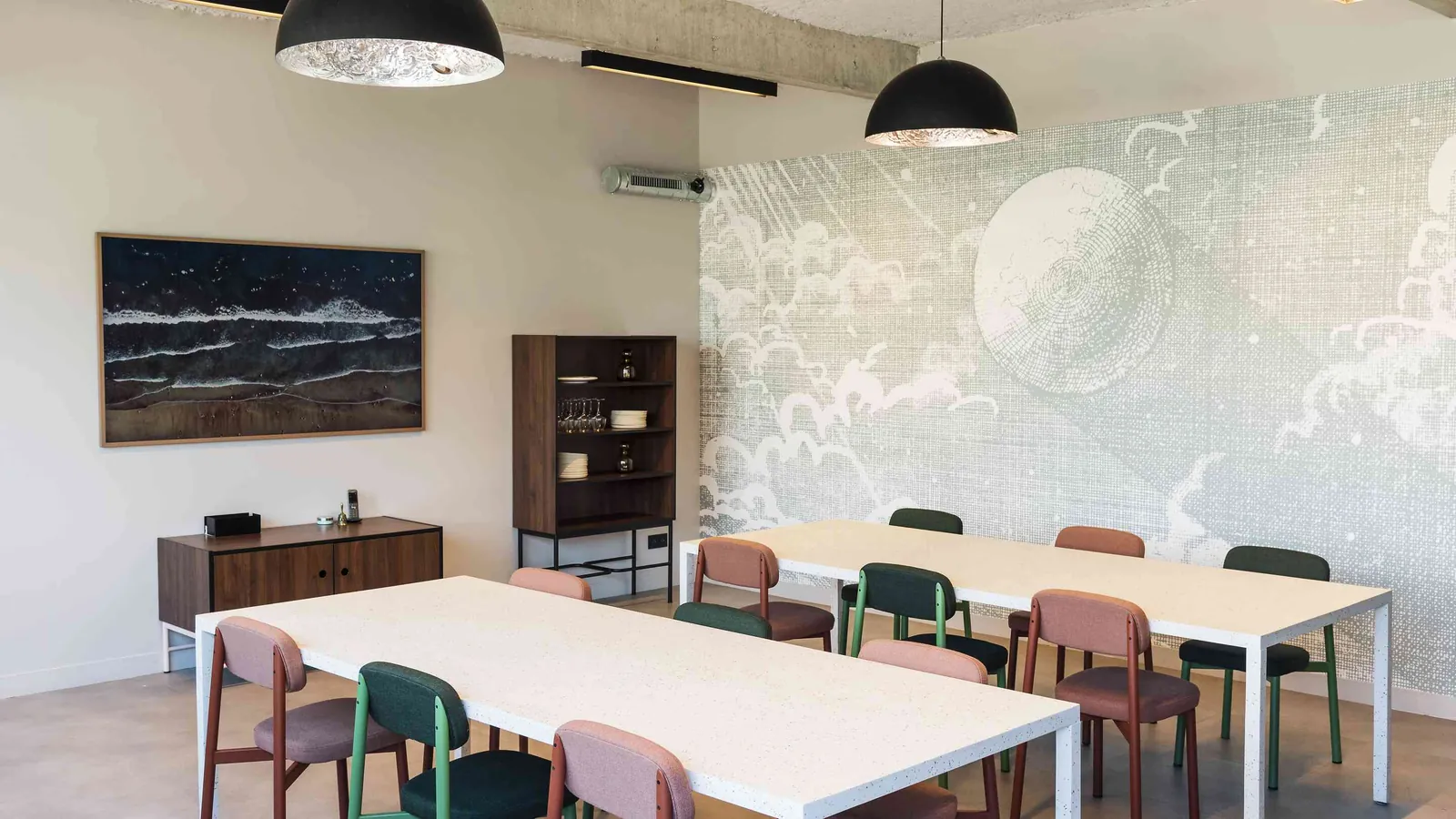 Salle de réunion du Belvédère Nord avec mur graphique, chaises pastel et longue table