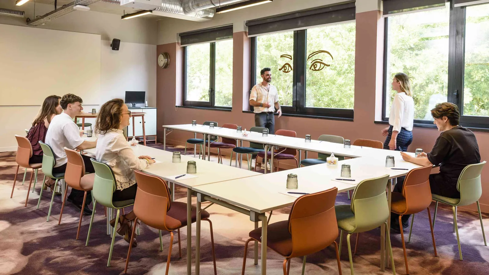 Salle de réunion du Belvédère Nord avec chaises rouges autour d'une longue table