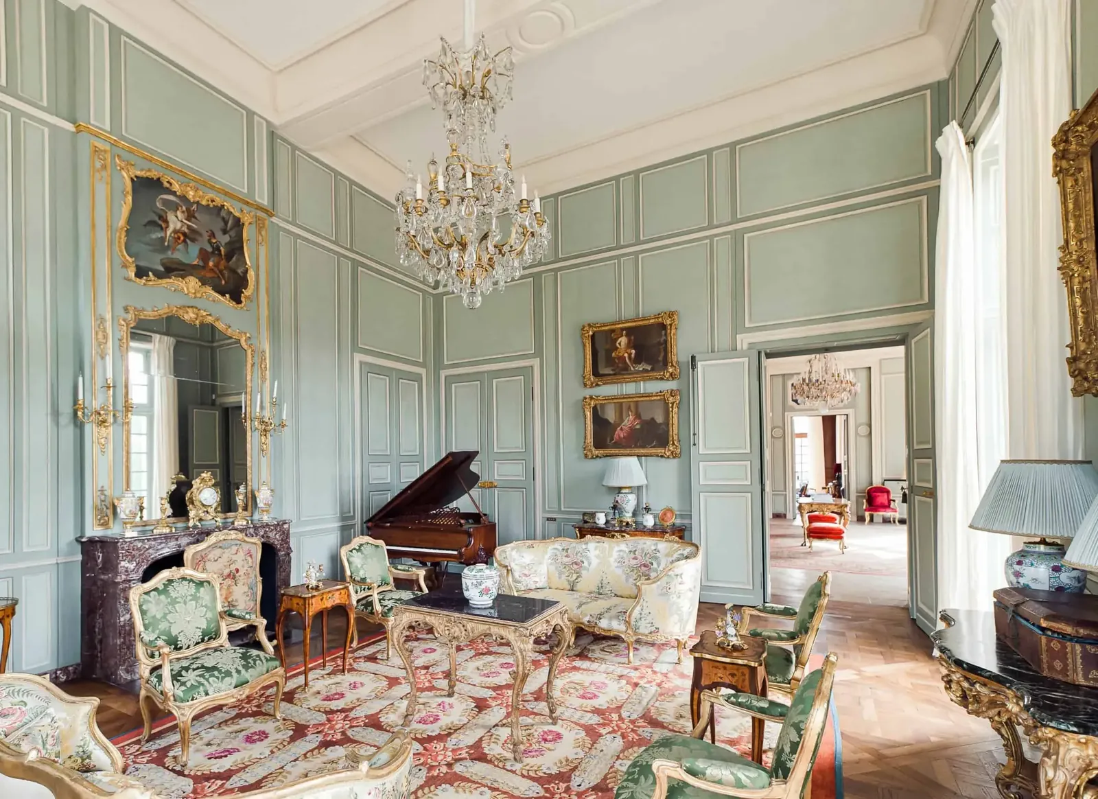 Château salon with chandeliers, period furniture and a patterned rug