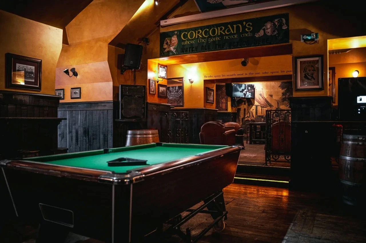 Pool table beside a wall of pub signage