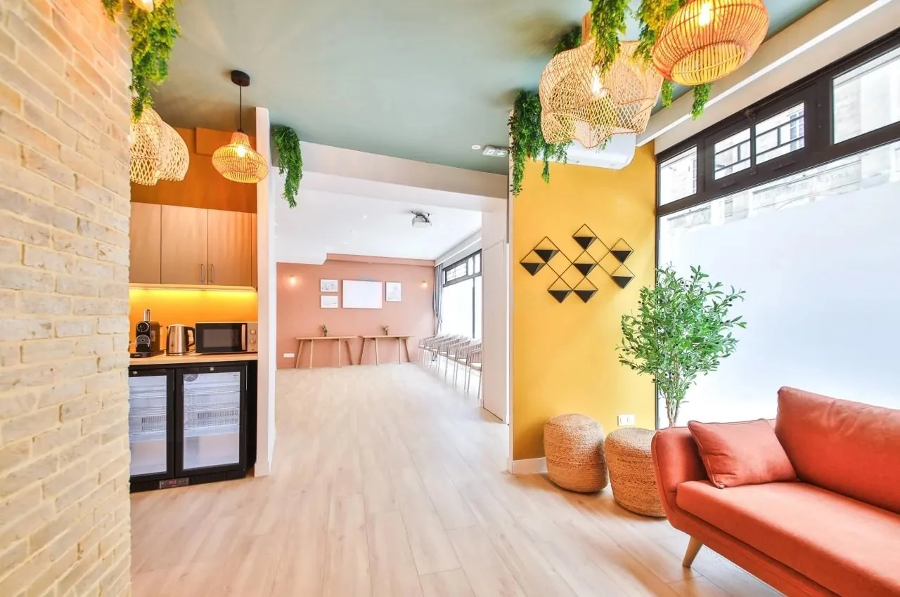 Kitchenette and lounge with a red sofa and plants