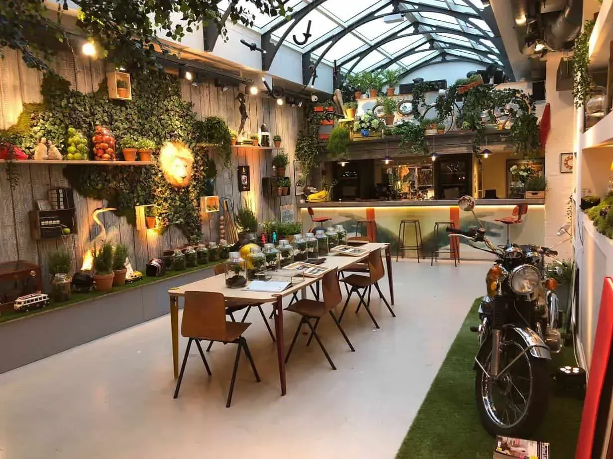 Glass-canopy space with greenery and vintage motorcycles