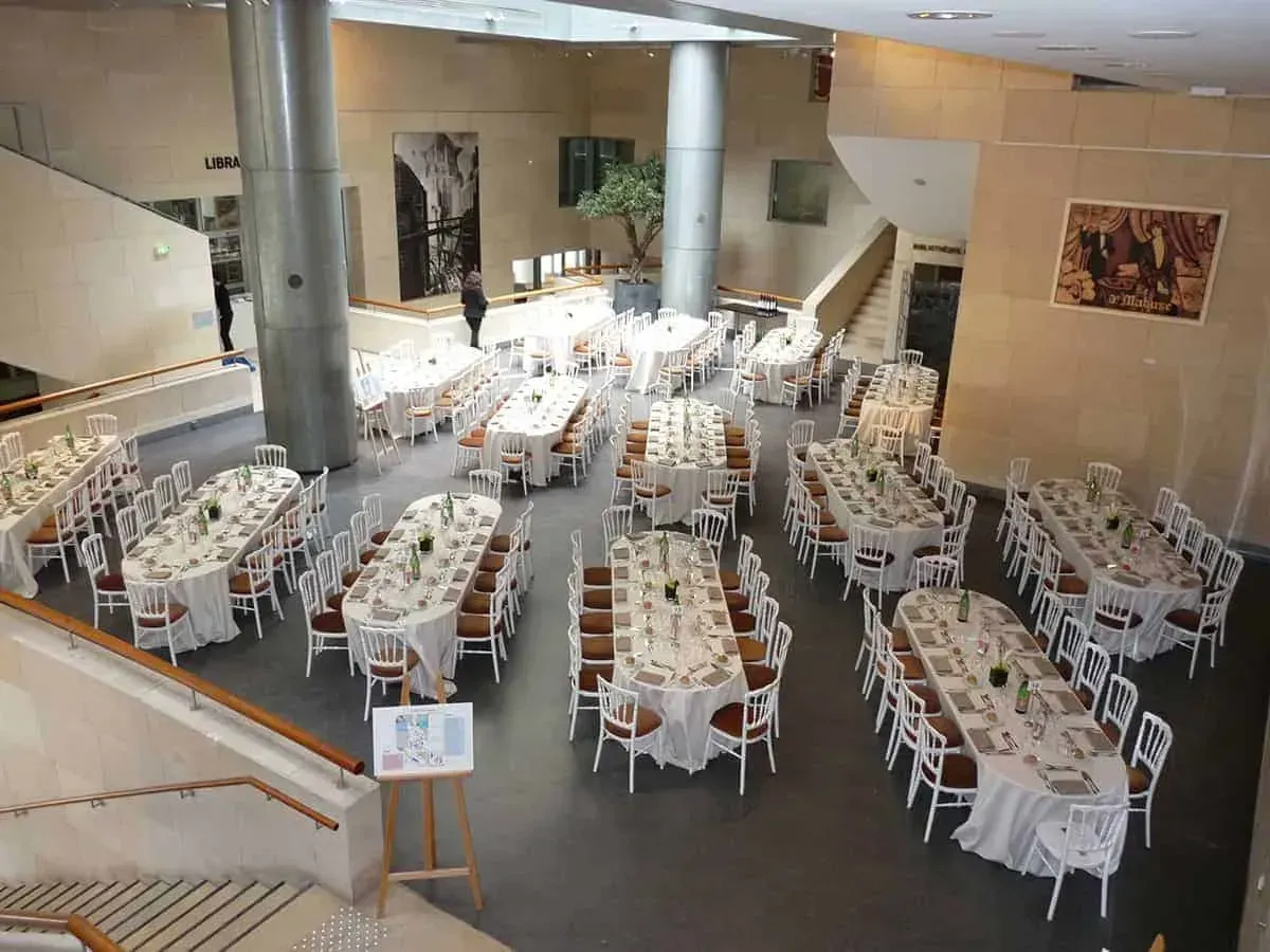 Banquet tables set in the stone atrium with stairs and columns