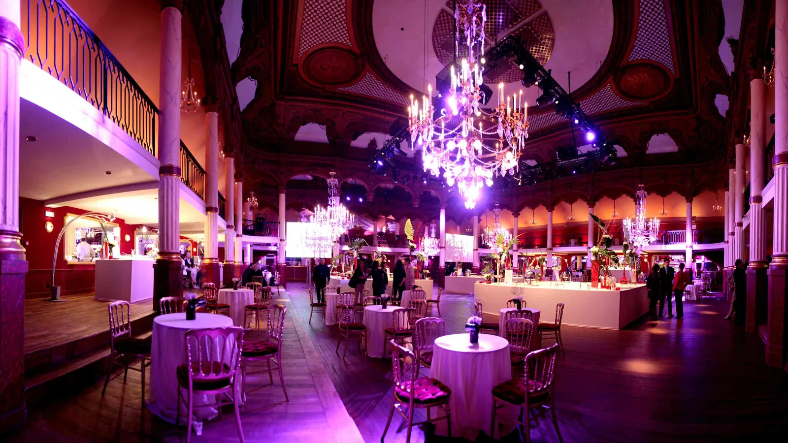 Réception au Grand Hall Étoile sous éclairage violet, lustres et tables rondes pour cocktail