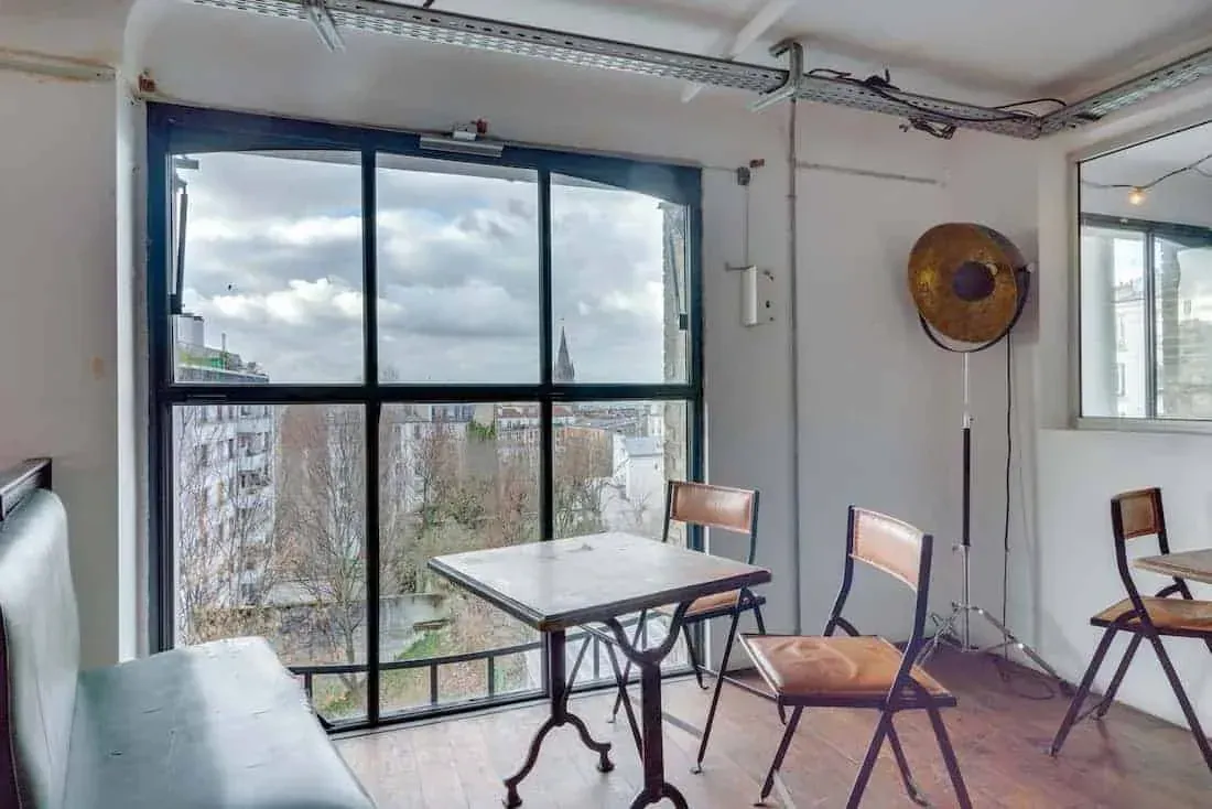 Mezzanine lounge with a window onto the street and a bistro table
