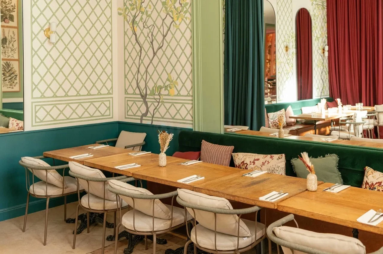 Dining room with a green velvet banquette and patterned wall panels