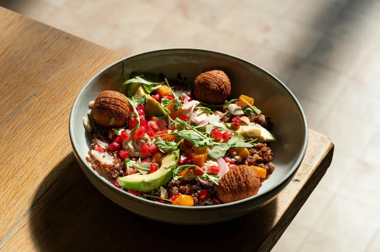 Plant-based bowl with grains, avocado and pomegranate seeds