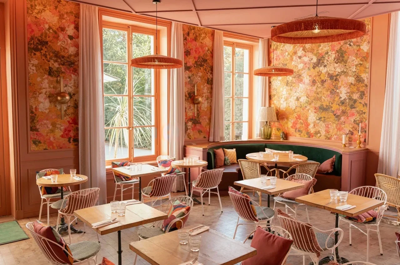 Restaurant room with pink floral walls and banquette seating