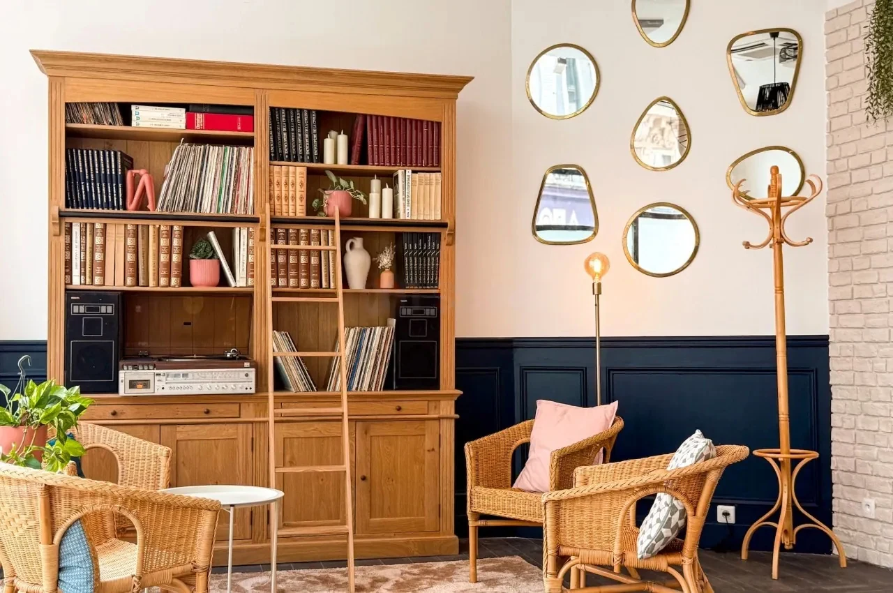 Lounge corner with bookcase, rattan armchairs and mirrors