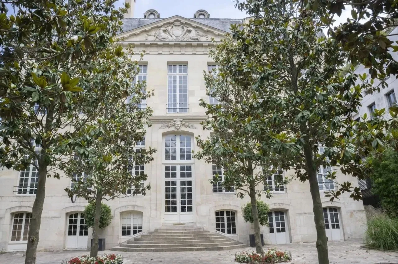 Classical façade of the hôtel particulier with trees in the courtyard