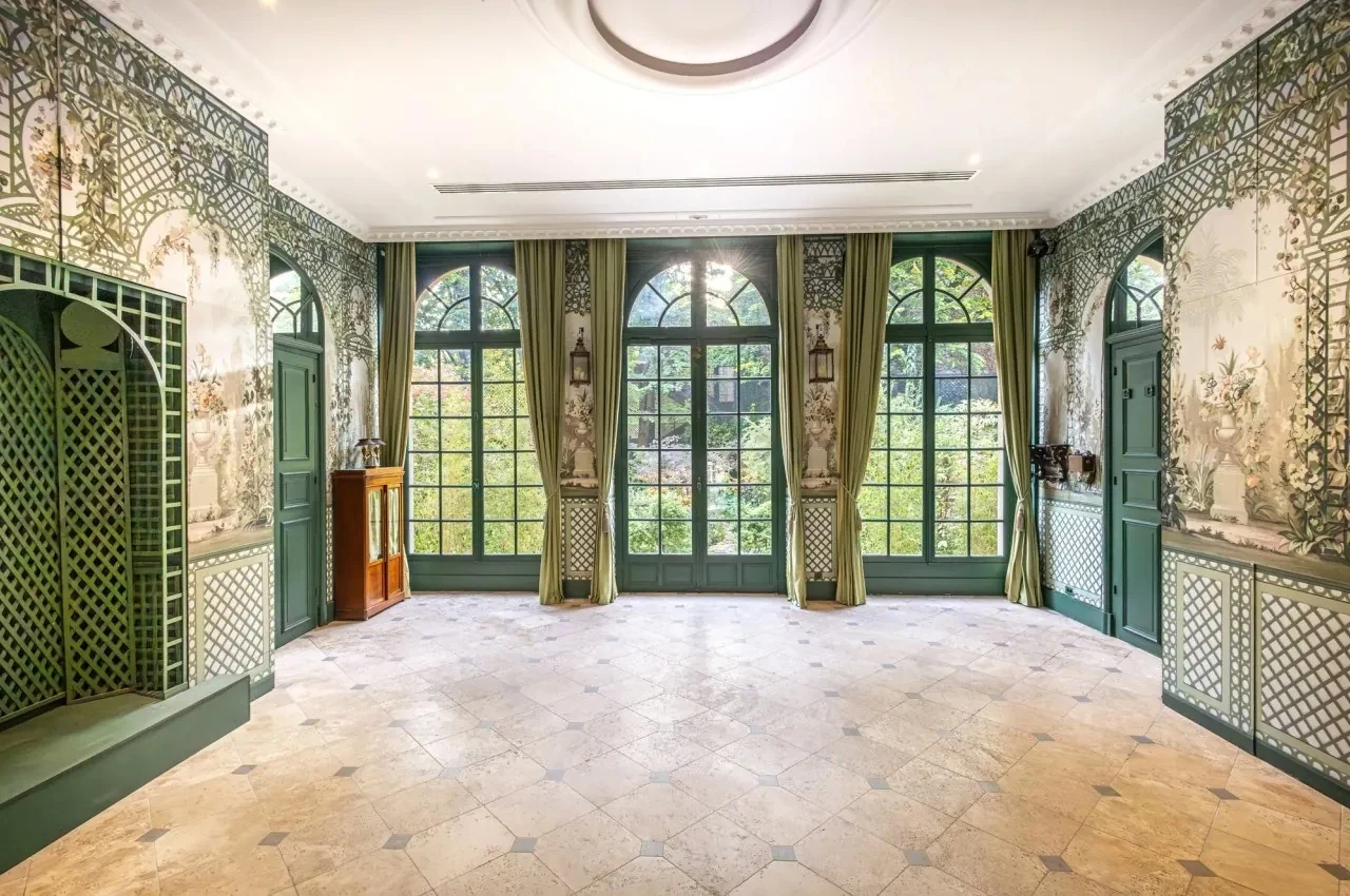 Salon with painted wall panels and tall windows set for a reception