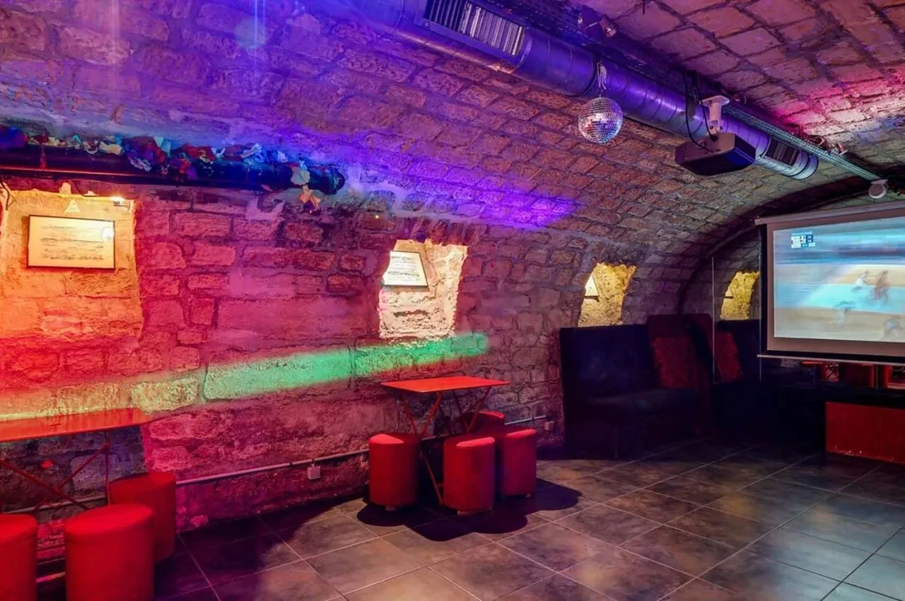 Lit stone walls and tables in the vaulted basement