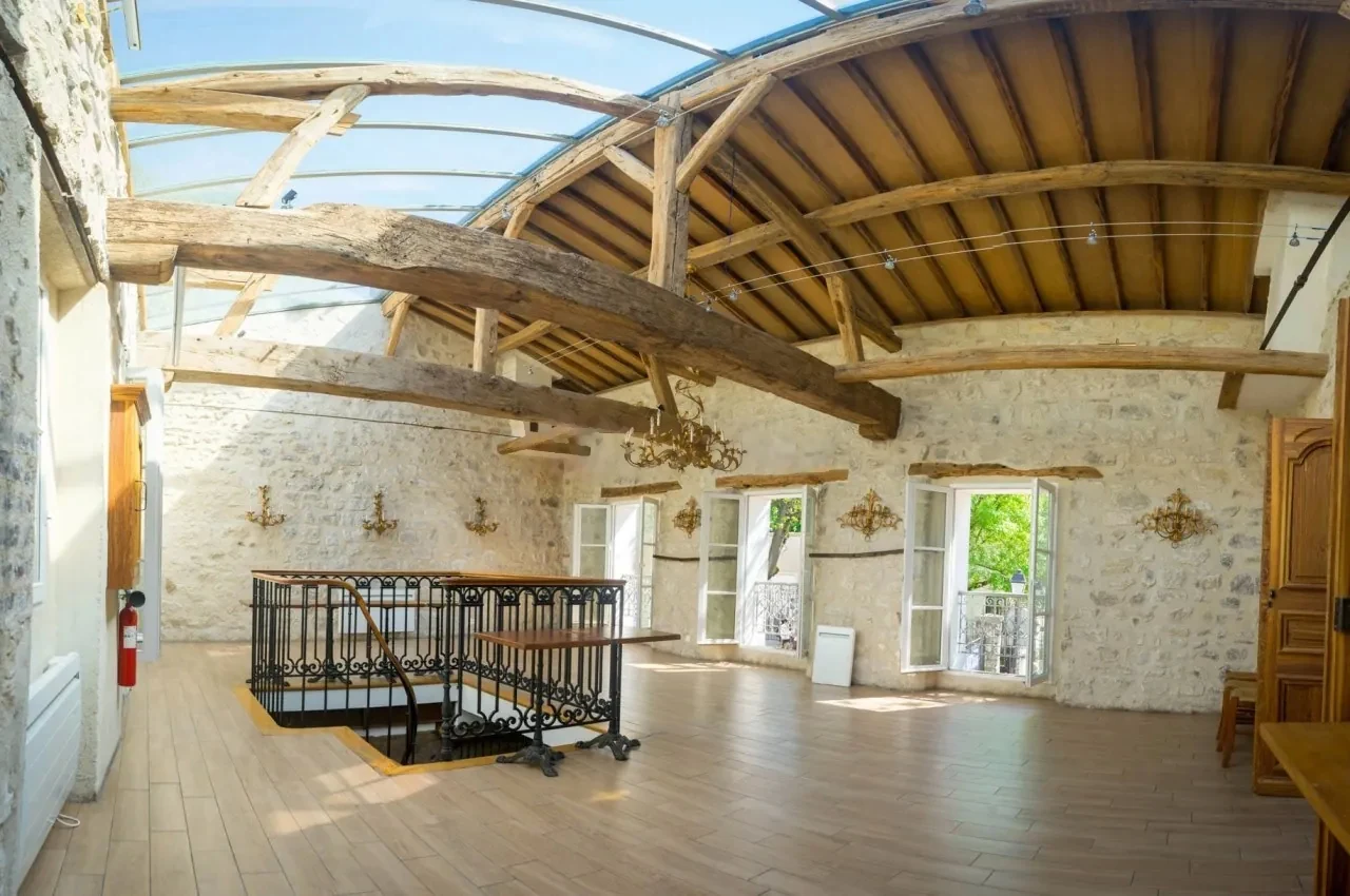 Beamed hall with stone walls and a metal balustrade