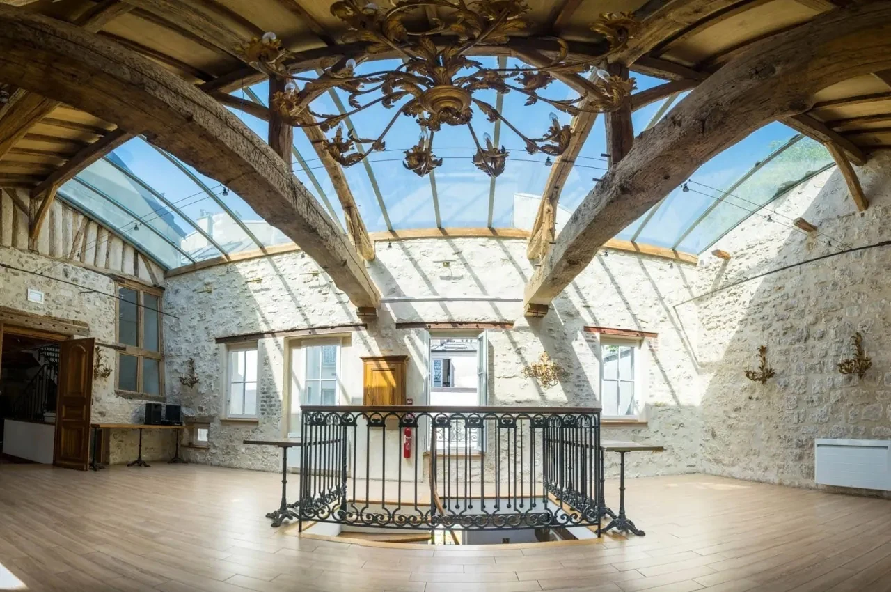Historic room with exposed beams, a glass roof and a metal balustrade