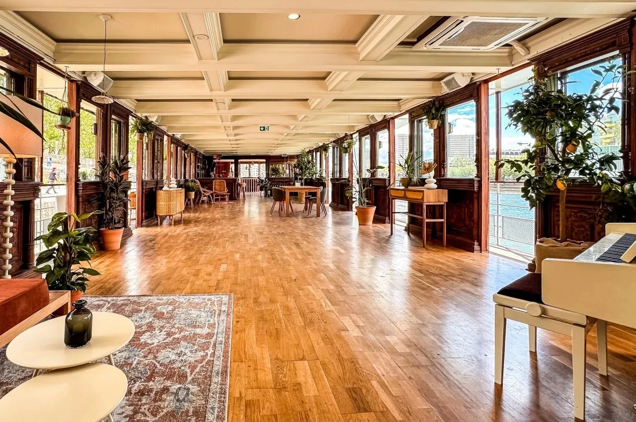 Interior salon with a coffered ceiling and tables along the windows