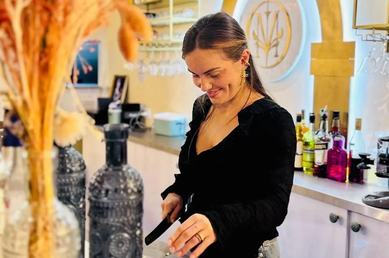 Bartender at the bar with decorated shelves
