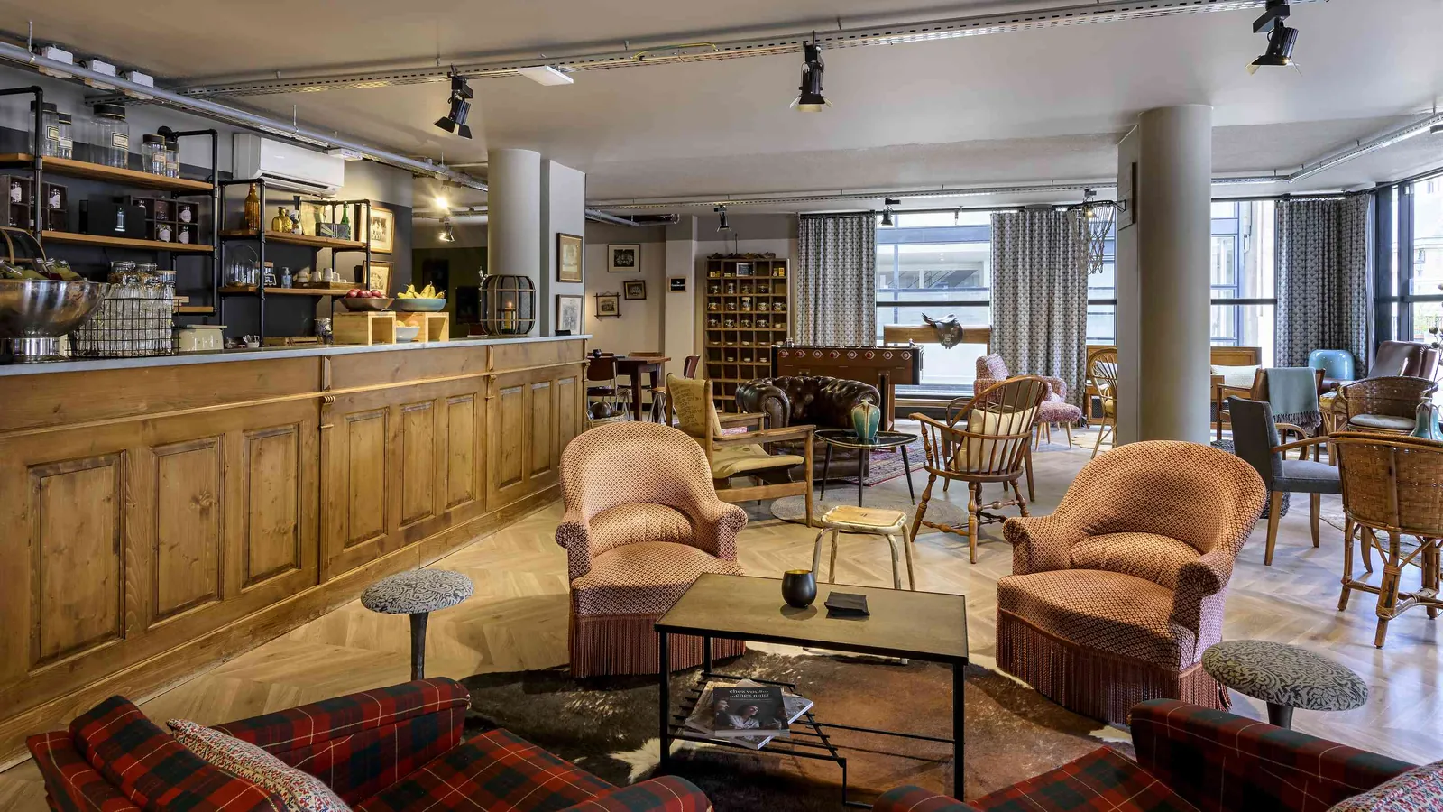 Bar salon de la Maison des Ateliers avec fauteuils en cuir, comptoir en bois et lampes vintage