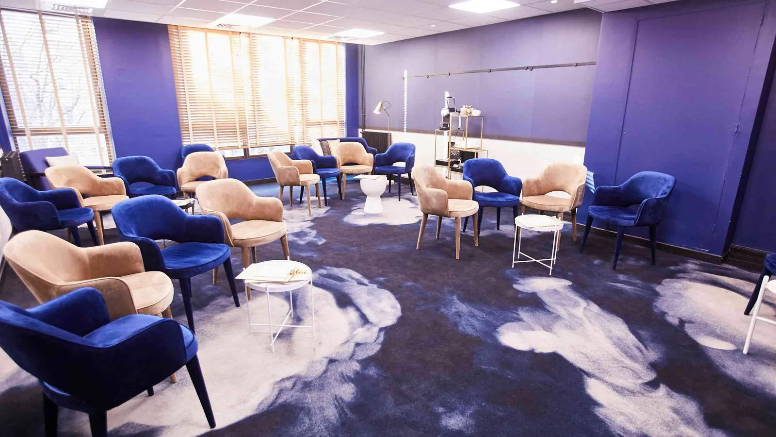 Golden House lounge with blue velvet armchairs, a cloud-patterned carpet and a tall window