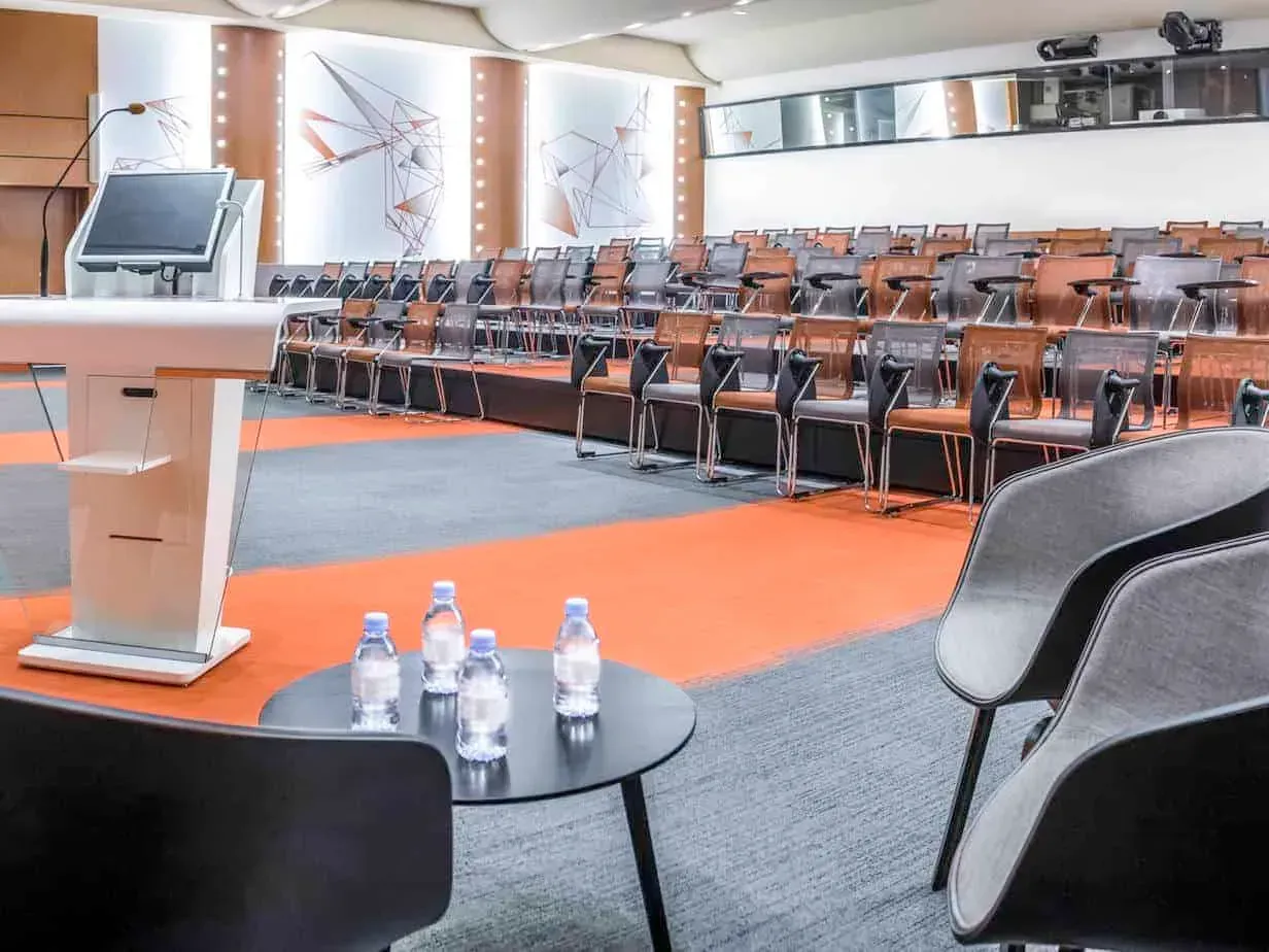 Lectern and water bottles at the front of the auditorium, with seating in rows