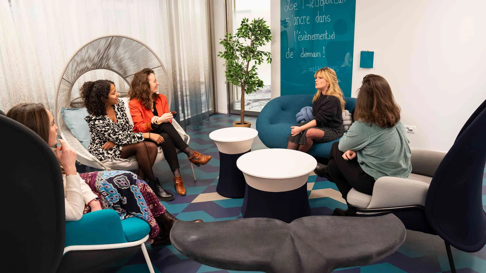 Salon du Pavillon Contemporain avec fauteuils bleu canard, poufs gris et plante verte