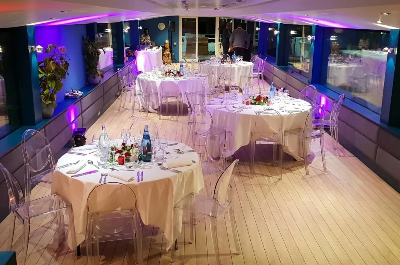 Dining tables set in the air-conditioned lounge with purple lighting