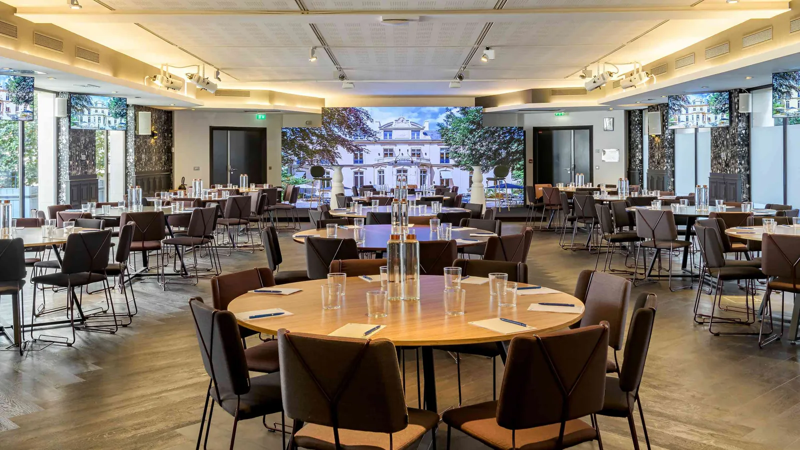Grande salle des Salons des Moulures, plafond mouluré et tables rondes dressées pour un dîner